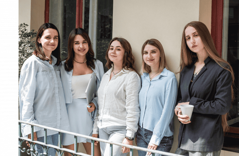 a group of woman standing on a balcony.