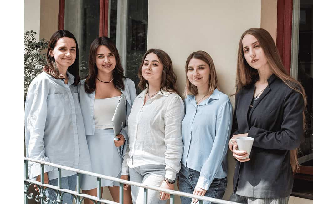 a group of woman standing on a balcony.