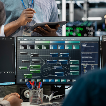 engineer with tablet reviewing industrial automation software display showing process flow diagram