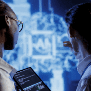 Two medical professionals analyzing brain MRI scan with AI diagnostic software on tablet device