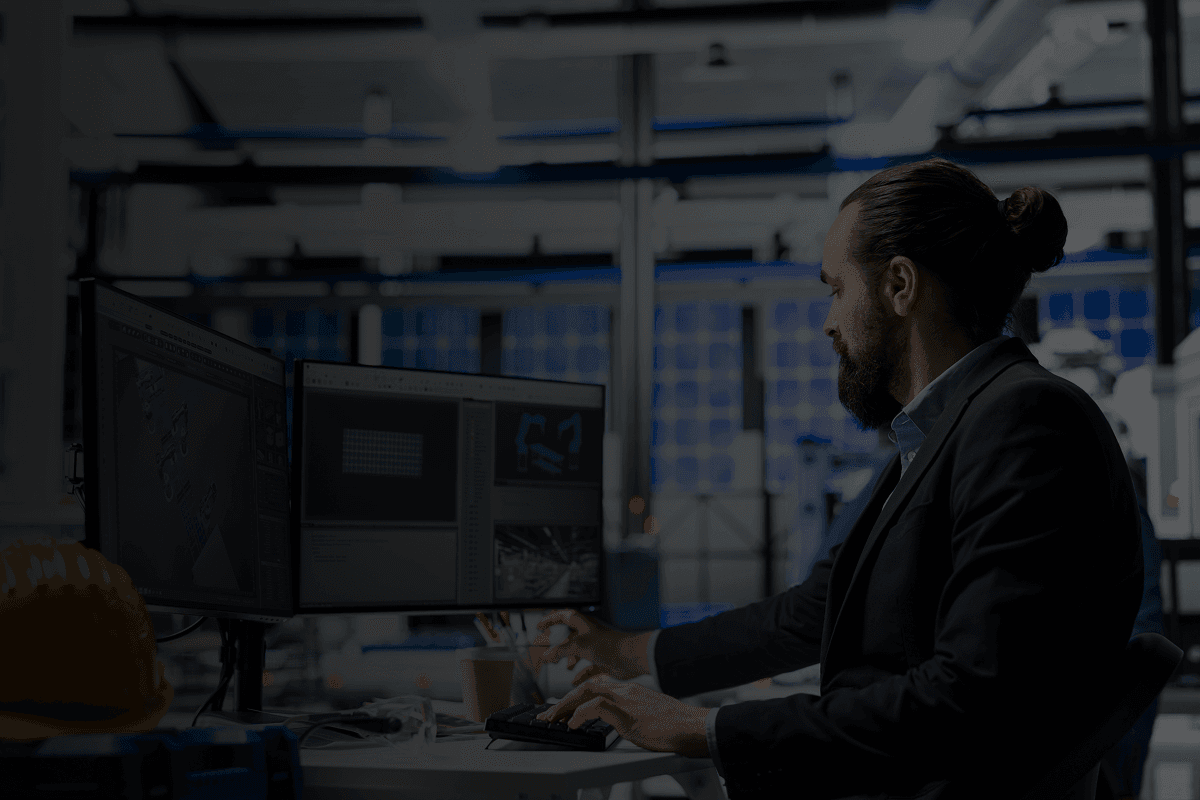 engineer working at computer in industrial facility with equipment
