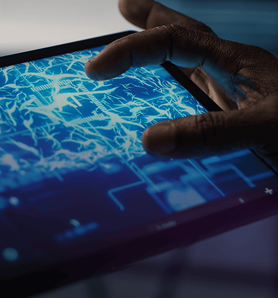 hands interacting with digital circuit board interface on tablet touchscreen displaying technology network